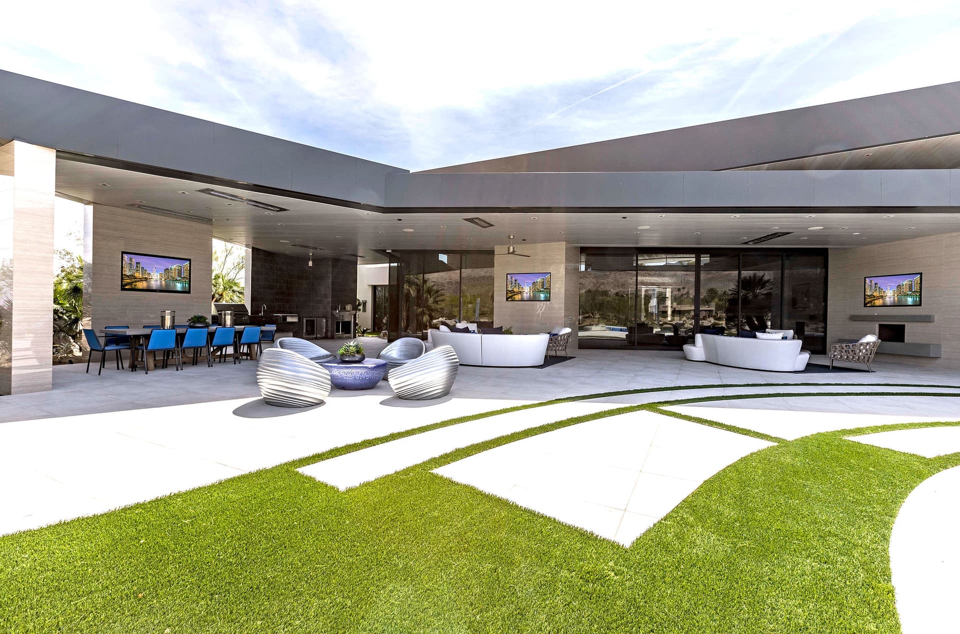 An indoor-outdoor space in California. The house has a large portion of glass wall that can be pushed away to create an open space, with central AV systems installed by AVIR.